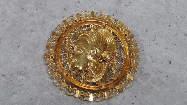 Broche ronde à décor de profil de femme Africaine en or filigrané...