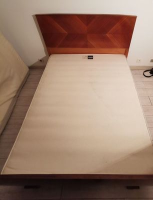 a bed with a wooden headboard and a brown head board