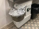 a trash can with tin foil on it next to a trash can