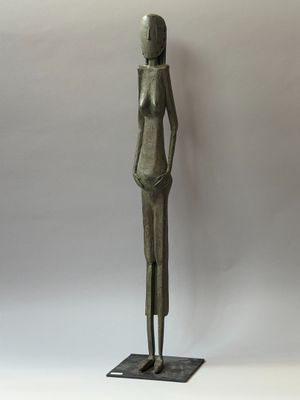 statue en bronze d'une femme debout sur un socle noir