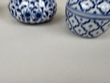 three small blue and white vases sitting on a table