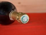 a bottle of wine sitting on a table with a red cloth