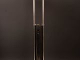 a black and silver lamp on a wooden table with a black background