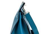 a teal blue leather handbag with a metal handle