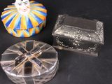 two small silver boxes with clown faces on them sitting on a black surface