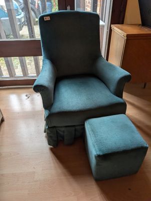 un fauteuil bleu et un pouf dans un salon équipé d'une porte-fenêtre coulissante