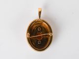 an image of a gold pendant with a circular design on it
