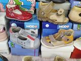many pairs of shoes that are sitting on a bed