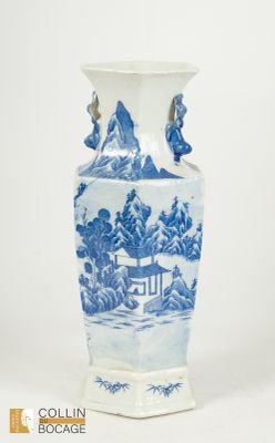 un vase bleu et blanc orné d'un paysage de montagne