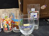 bottles and glasses are lined up on a table next to a cardboard box