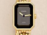 a close up of a gold wrist watch with a black face