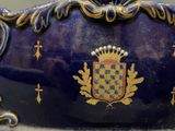 a blue and gold vase with a crown on it