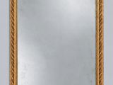 a gold framed mirror on a wall with a white background