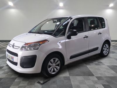 la petite camionnette blanche est garée sur un carrelage à carreaux