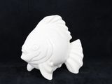 une figurine de poisson blanc posée sur une surface noire