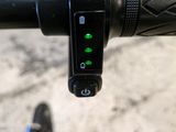 a close up of a bicycle handlebar with a green light