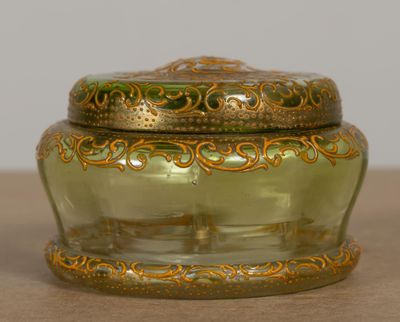 un bocal en verre vert orné d'un motif doré