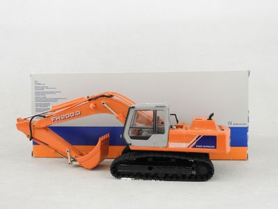a toy excavator that is sitting next to a box