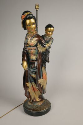 statue représentant une femme tenant un enfant et une lampe posées sur une table