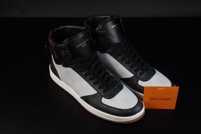une paire de baskets noires et blanches posées sur une surface noire