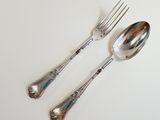 two spoons and a fork on a white table