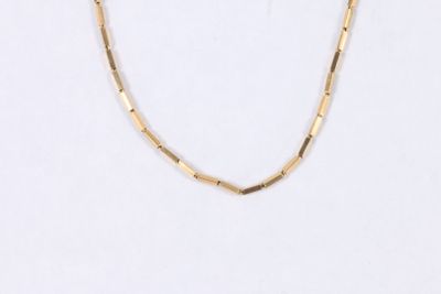gros plan d'un collier en or sur fond blanc