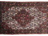 un tapis persan ancien aux motifs rouges et noirs