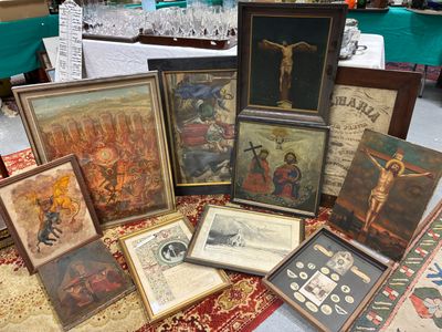 de nombreuses œuvres d'art religieux, encadrées ou non, posées sur une table