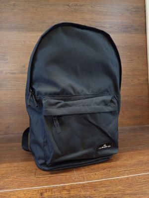 un sac à dos noir posé sur les marches d'un immeuble