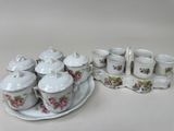 une assiette sur laquelle sont posées des tasses et des soucoupes, à côté d'un plateau sur lequel sont posées des tasses et des soucoupes