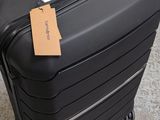 a black suitcase with a tag on it sitting on the floor