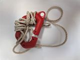 a red life preserver and a rope on a white surface