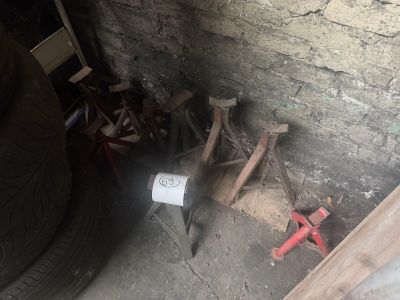 a white toilet sitting in the corner of a room next to a pile of wood