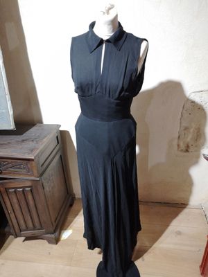 a black dress on a mannequin stand in a room
