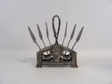 a metal holder with knives on it on a white surface