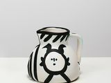 a black and white vase with a face painted on it