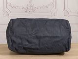 the large black bag is sitting on the table in front of a wall
