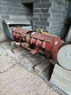 un tracteur rouge garé à côté d'un bâtiment