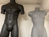 two mannequins sitting on a shelf next to each other