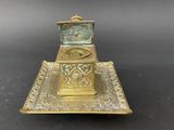 a brass plate with a clock on top of it on a black surface
