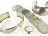 a silver ring and a silver cuff with a coin on it