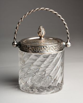 an antique silver plated glass ice bucket with a handle