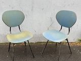 two chairs sitting next to each other on the pavement