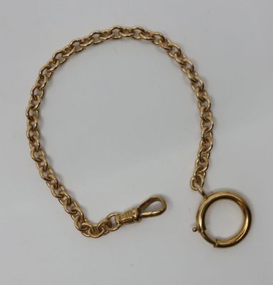 un gros plan d'un bracelet en chaîne dorée sur lequel est enfilé un anneau