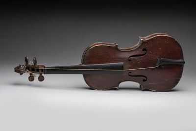 an old violin sitting on top of a white surface