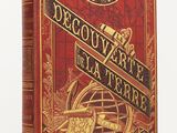 la couverture d'un livre rouge et or sur laquelle figure un compas