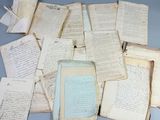 beaucoup de vieux papiers et une bouteille sur la table