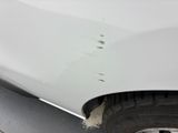 a close up of a white car with a hole in the side