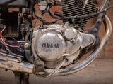 a close up of a motorcycle engine with a brick wall in the background