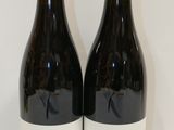 deux bouteilles de vin posées l'une à côté de l'autre sur une table
